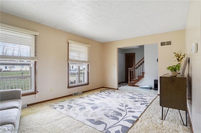 living area featuring light carpet and a textured ceiling