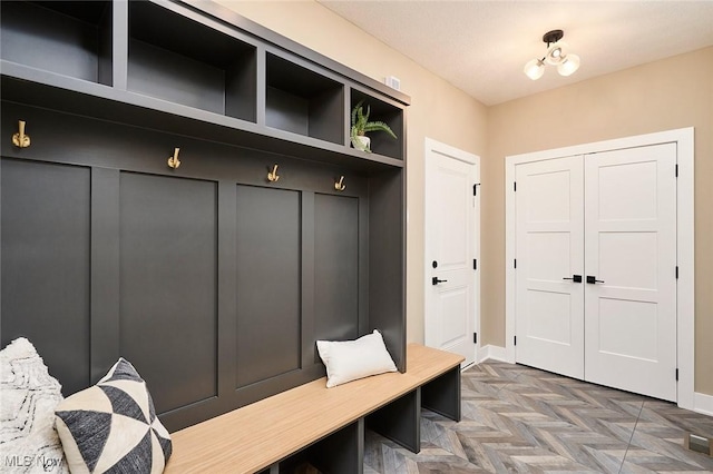 mudroom with a chandelier and dark parquet floors