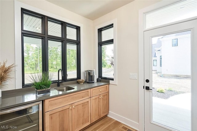 entryway featuring sink, wine cooler, and light hardwood / wood-style flooring