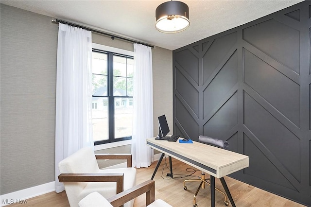 home office with light hardwood / wood-style flooring