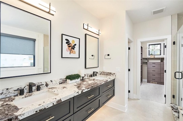 bathroom with tile patterned floors, vanity, and walk in shower