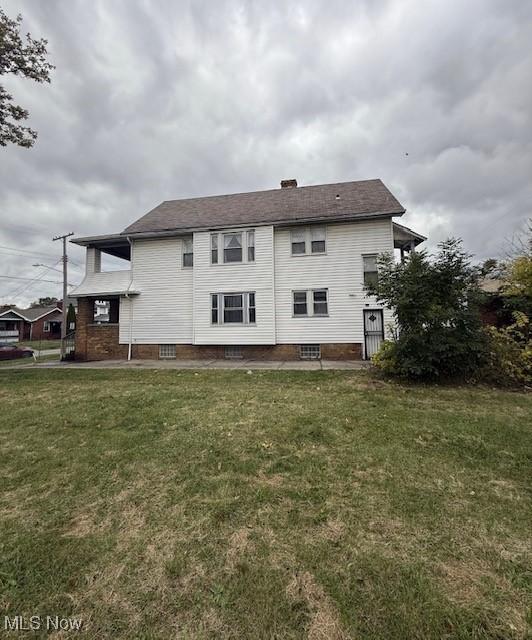 rear view of property with a lawn