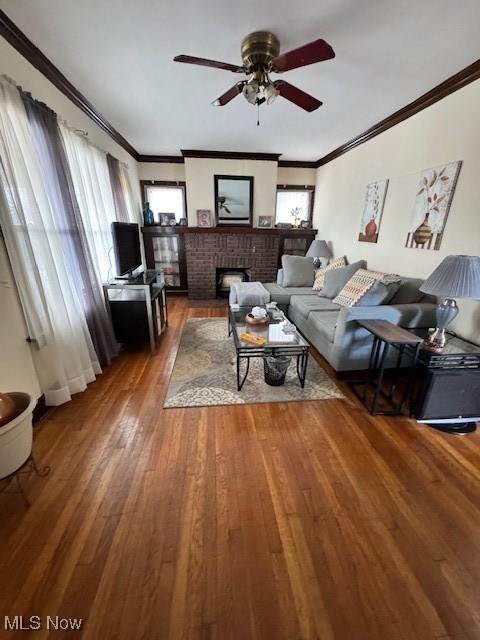 living room featuring plenty of natural light, ceiling fan, wood-type flooring, and a fireplace