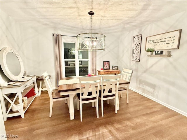 dining space featuring hardwood / wood-style floors and a notable chandelier