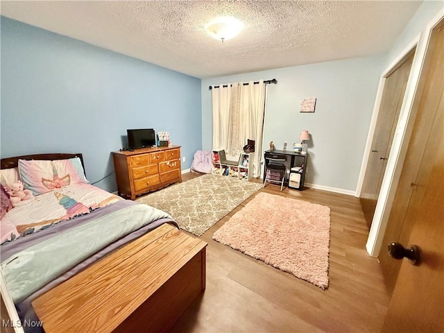 bedroom featuring light wood-type flooring and a textured ceiling