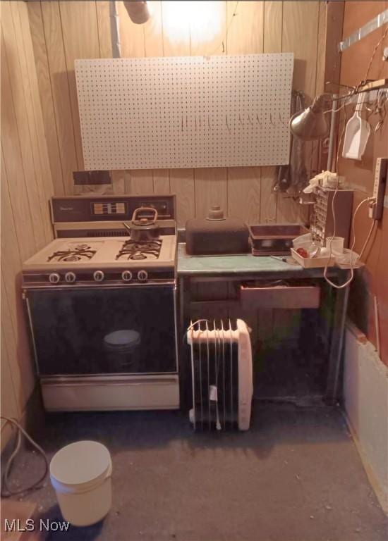 interior space with wood walls, range, and exhaust hood