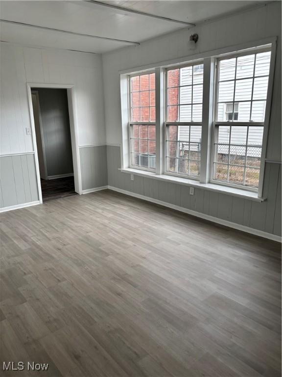 934 Main St, Wellsville, OH 43968 - unfurnished room with wood finished floors, a decorative wall, and wainscoting