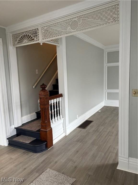 stairway featuring wood-type flooring and ornamental molding