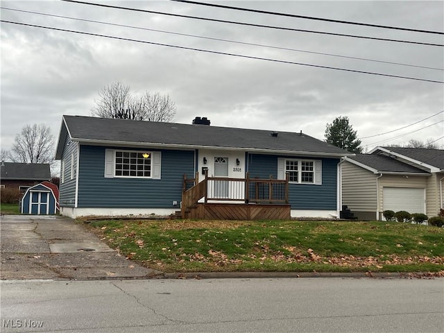 ranch-style home with a storage shed and a front yard