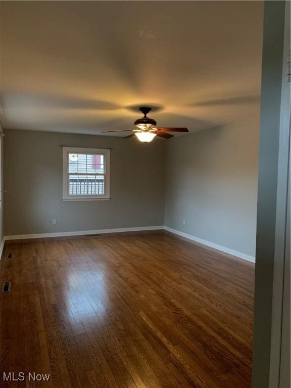 unfurnished room with ceiling fan and dark hardwood / wood-style flooring