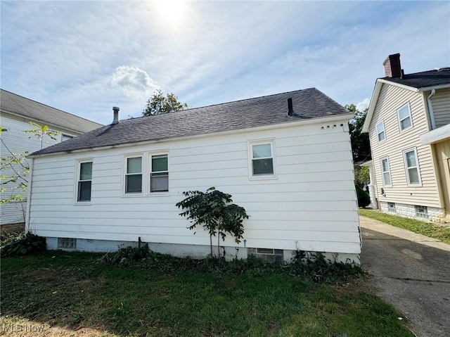 view of side of home with a yard