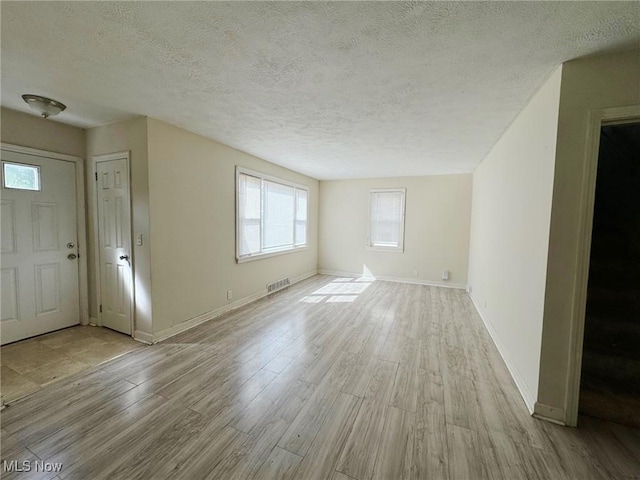 interior space featuring light hardwood / wood-style floors and a textured ceiling