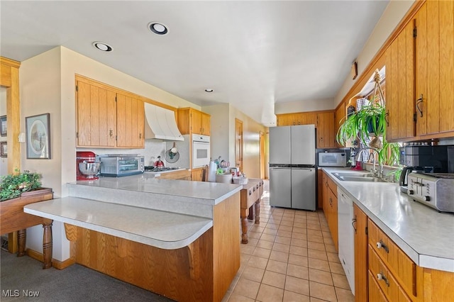 kitchen with backsplash, ventilation hood, stainless steel appliances, sink, and light tile patterned floors