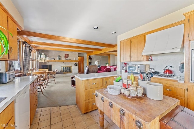 kitchen with beam ceiling, dishwasher, a kitchen island, a fireplace, and light tile patterned flooring