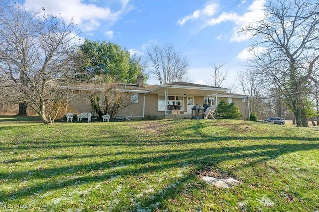 back of property featuring a lawn and a porch