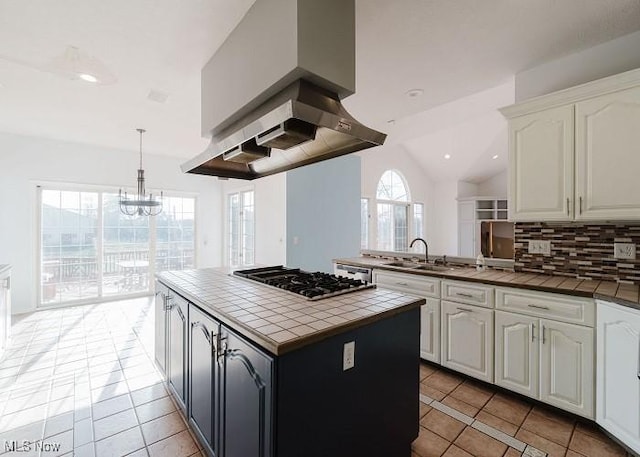 kitchen with white cabinets, decorative backsplash, tile counters, and sink