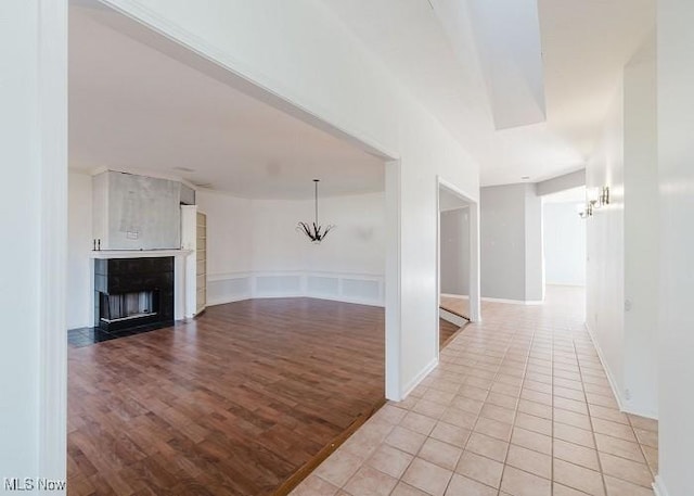 unfurnished living room featuring light hardwood / wood-style floors and a chandelier