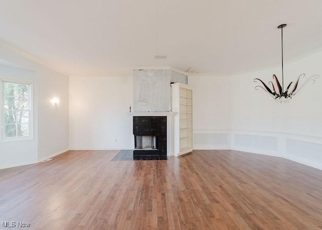 unfurnished living room with crown molding and wood-type flooring