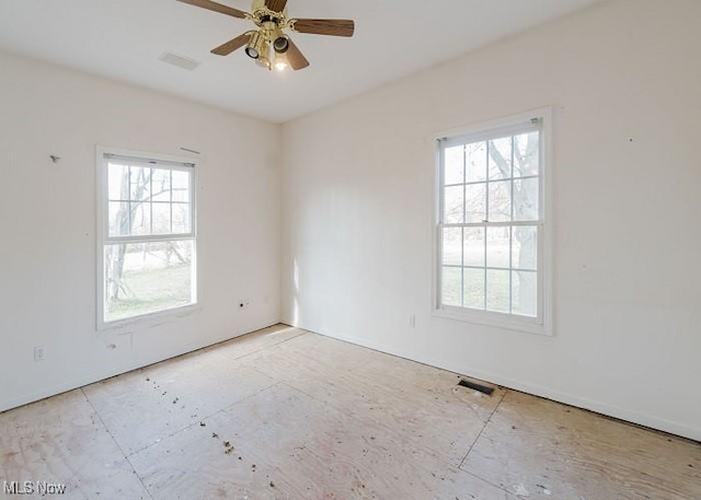 spare room featuring ceiling fan and plenty of natural light