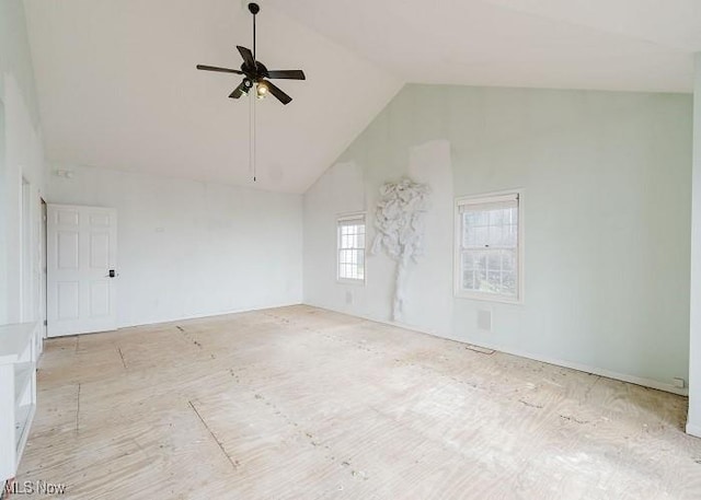 unfurnished room with ceiling fan and high vaulted ceiling