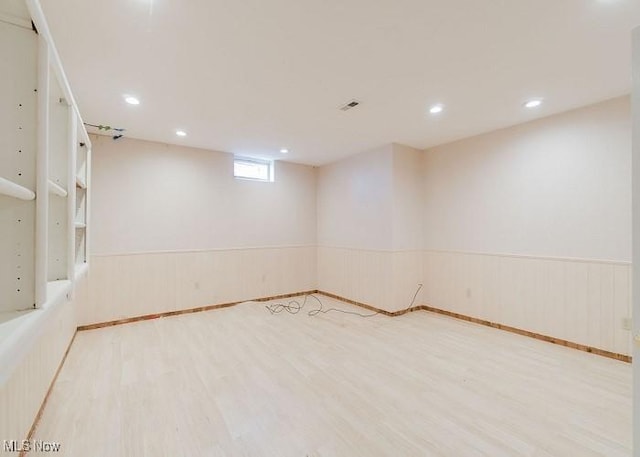 basement with light hardwood / wood-style flooring