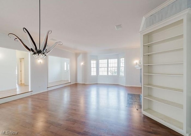 interior space with built in shelves, wood-type flooring, and an inviting chandelier