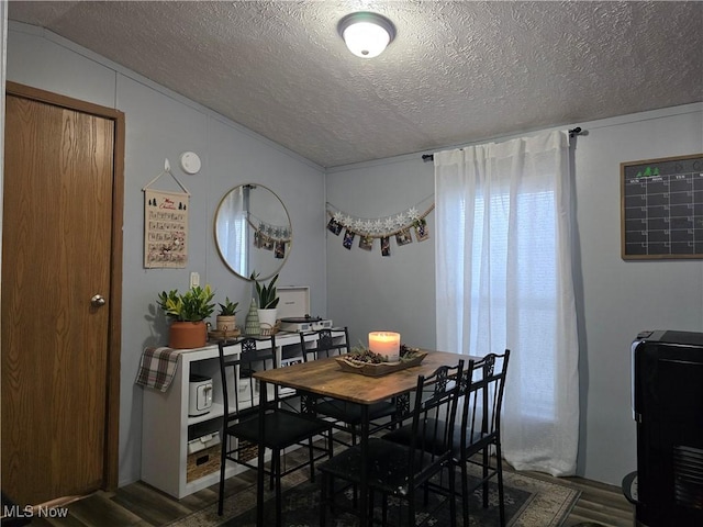 dining area featuring a textured ceiling and dark hardwood / wood-style floors