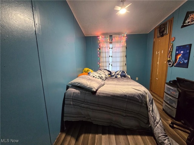 bedroom with ceiling fan, hardwood / wood-style floors, and crown molding