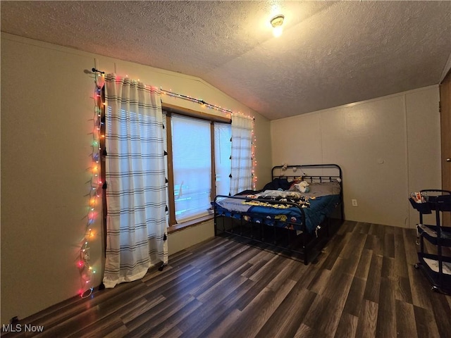 bedroom featuring a textured ceiling, dark hardwood / wood-style flooring, and vaulted ceiling