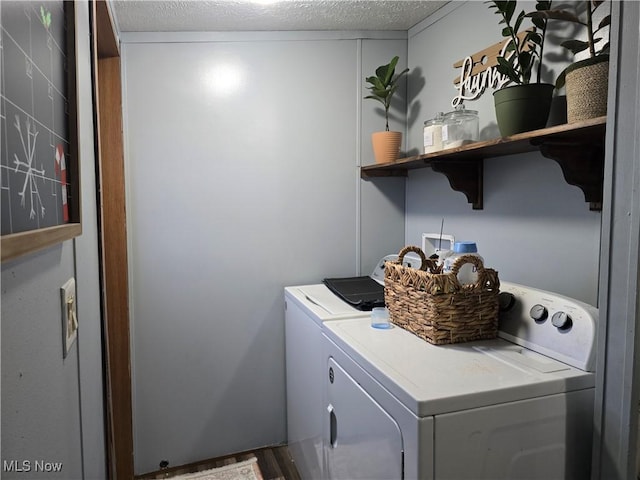 laundry room with hardwood / wood-style floors, washer and dryer, and a textured ceiling