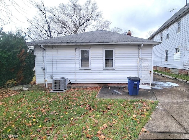 view of property exterior with cooling unit and a yard