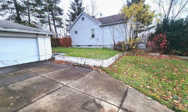 view of side of property with a lawn and a garage