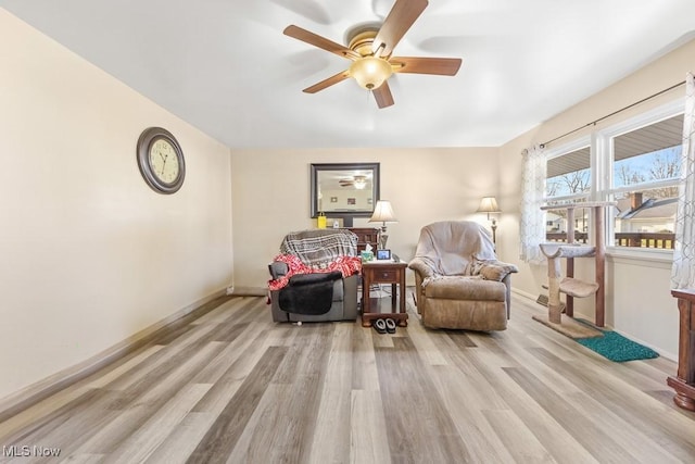 living area with ceiling fan and light hardwood / wood-style floors