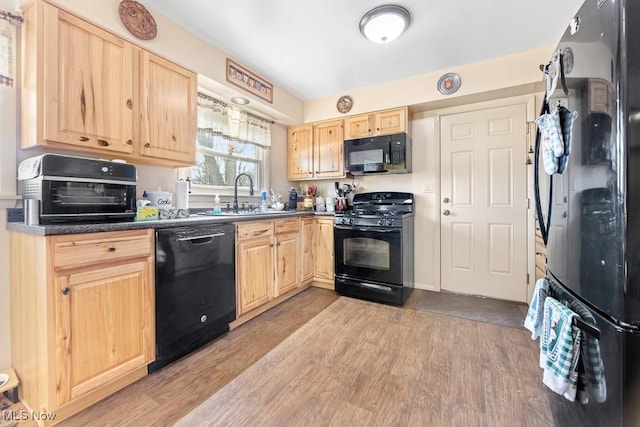 kitchen with light brown cabinets, sink, light hardwood / wood-style floors, and black appliances