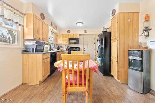 kitchen featuring sink, light brown cabinets, black appliances, and light hardwood / wood-style flooring