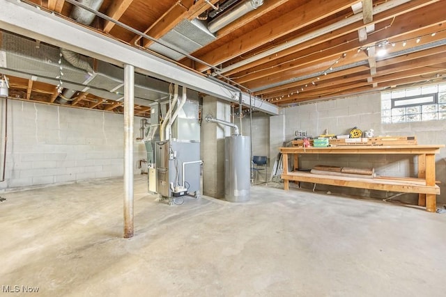 basement with a workshop area, heating unit, and water heater