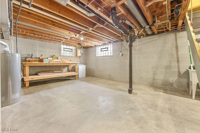 basement featuring a workshop area, electric panel, and water heater