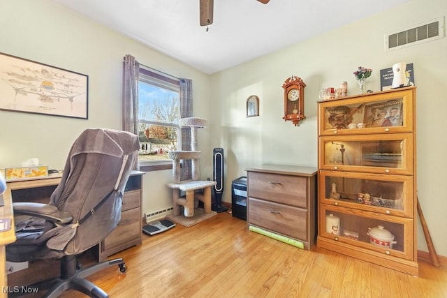 office area with ceiling fan, light hardwood / wood-style flooring, and a baseboard radiator