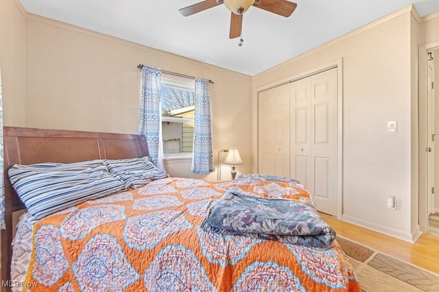 bedroom featuring hardwood / wood-style flooring, ceiling fan, ornamental molding, and a closet