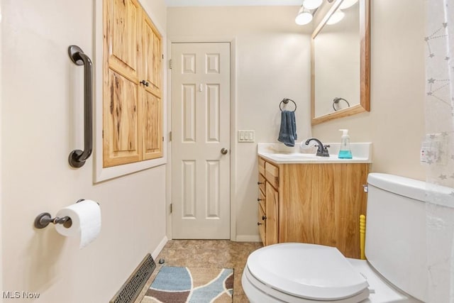 bathroom featuring tile patterned flooring, vanity, and toilet