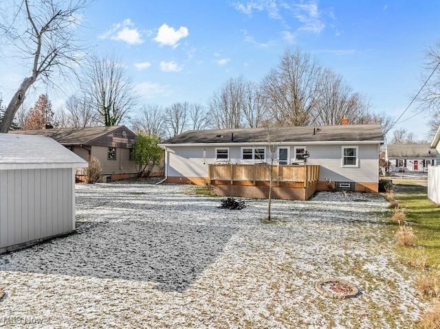 back of house with a shed and a deck