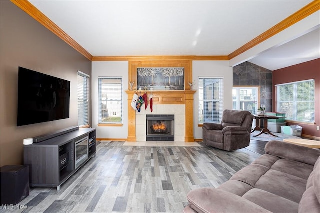 living room featuring wood-type flooring, plenty of natural light, and ornamental molding