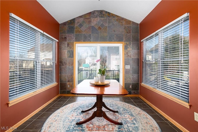 interior space featuring vaulted ceiling, tile walls, and a healthy amount of sunlight