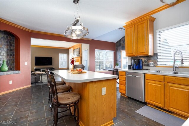 kitchen with a wealth of natural light, a center island, stainless steel dishwasher, and decorative light fixtures