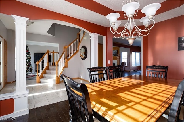 dining area featuring dark wood-type flooring, a textured ceiling, and a notable chandelier