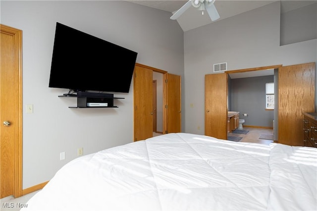 bedroom with ensuite bathroom, ceiling fan, and high vaulted ceiling