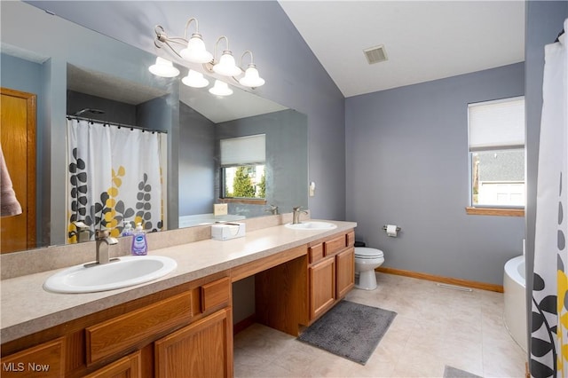 bathroom featuring tile patterned floors, vanity, vaulted ceiling, and toilet