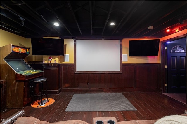 cinema room with dark hardwood / wood-style flooring and wood walls