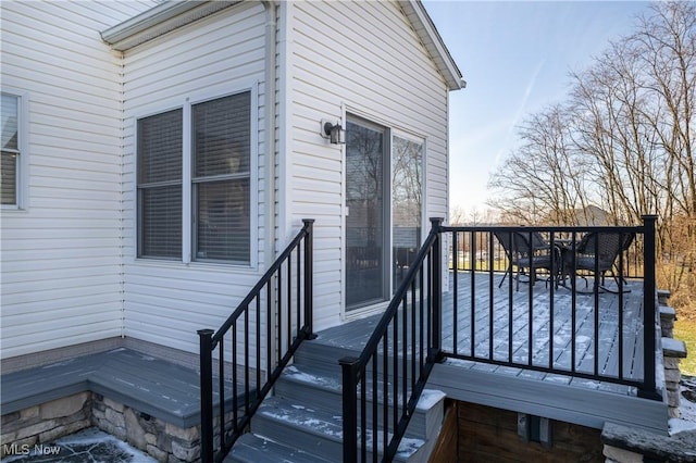 exterior entry at dusk featuring a wooden deck