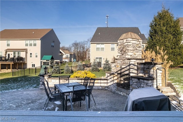 view of patio / terrace with an outdoor stone fireplace and a grill